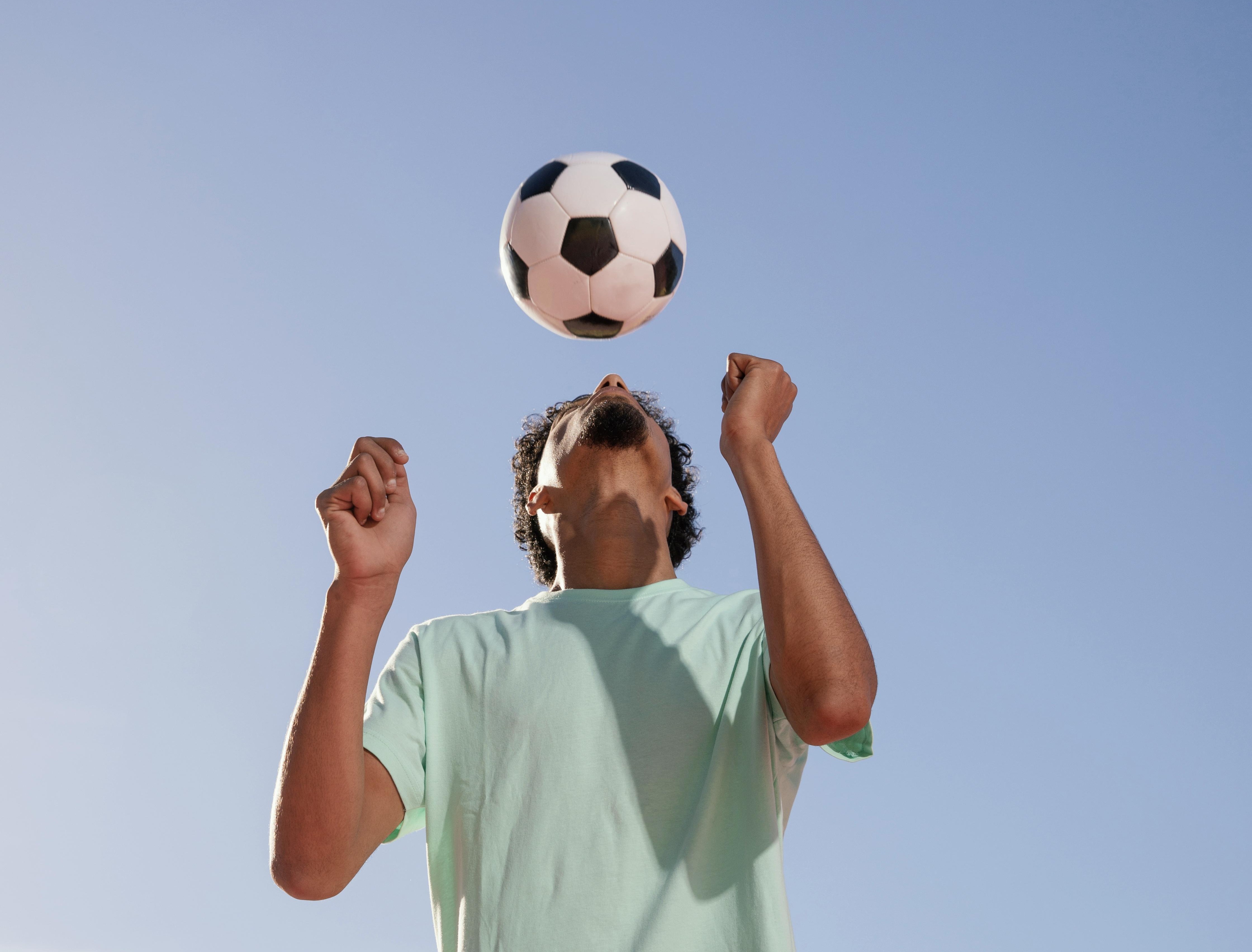 Jogador de futebol a cabecear uma bola de futebol